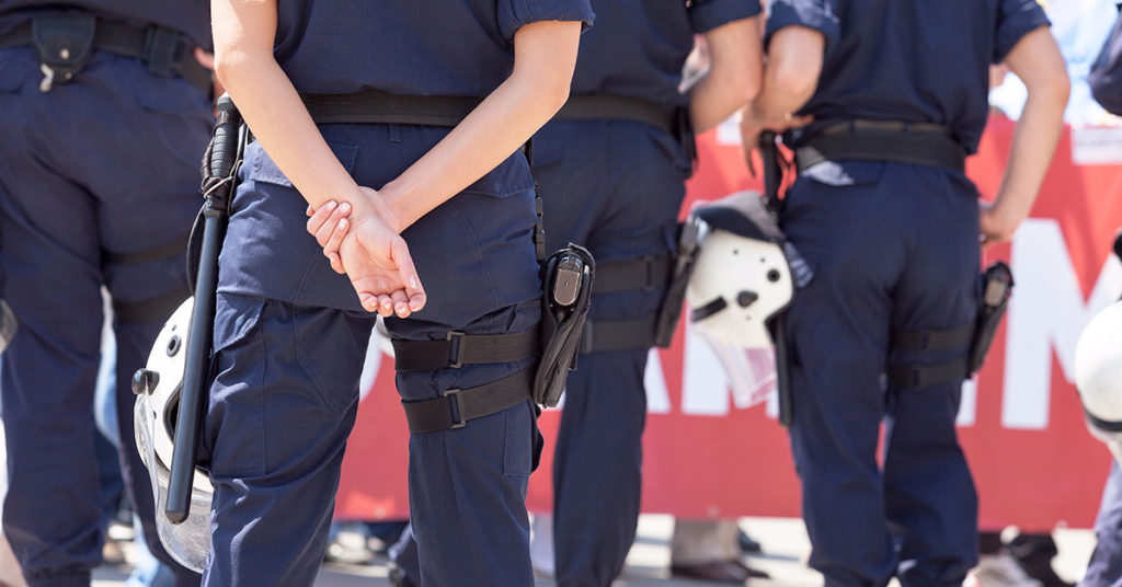 Segurança Pública: vários policiais de costas enquadrados do tórax à panturrilha.